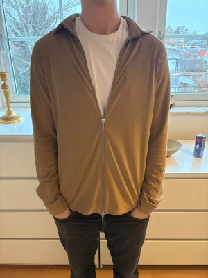 Beige overshirt från Ciszere - Säljer en stilren beige overshirt från Ciszere i mockaimitation. Jackan har slim fit, dragkedja framtill och klassisk krage. Perfekt att slänga över en t-shirt för en clean look.