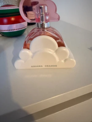 Ariana Grande Cloud pink parfym 30ml - Snygg parfym från Ariana Grande med rosa flaska och moln-detalj. Volymen är 30 ml. Tillverkad i Frankrike. Perfekt för dig som vill ha en trendig doft i väskan.