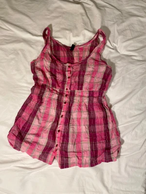 Rurig, rosa baby doll topp från Vero Moda - Jättesöt babydoll linne från Vero Moda. Detta bomulls linne är så gulligt och har så fin modell med fina knappar. #babydoll linne #rutigt linne #knappar #rosa