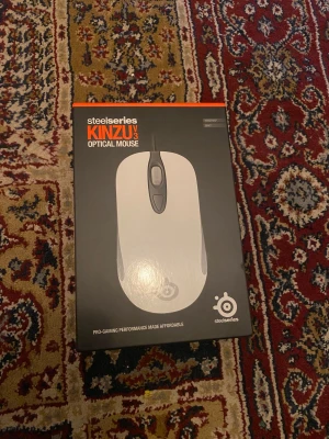 SteelSeries Kinzu V3 Optical Mouse - SteelSeries Kinzu V3 är en optisk gamingmus med 2000 CPI, 1ms responstid och hållbara switchar för upp till 10 miljoner klick. Kompakt och ambidextrous design, perfekt för både höger- och vänsterhänta. Levereras i originalkartong, helt ny!