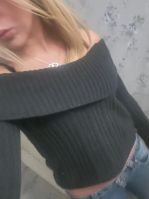 Mörkgrå offshoulder stickad tröja - Snygg mörkgrå stickad tröja med bred offshoulder-krage som ger en chill vibe. Ribbad struktur och långärmad modell, perfekt att matcha med jeans. Tröjan är loose fit och har en mysig känsla, passar dig som gillar trendiga och bekväma plagg. Storleken är i barnstorlek men skulle säga att den passar Xs💞