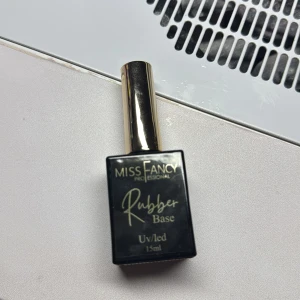 Miss Fancy Rubber Base UV/LED 15ml - Miss Fancy Professional Rubber Base för naglar, 15 ml. Kommer i en svart fyrkantig flaska med guldfärgat lock och söt rosa hjärta på toppen. Perfekt för att bygga upp och stärka naglarna innan färg. Passar UV/LED-lampa.