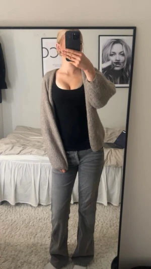 Grå bootcut jeans med broderad ficka - Säljer ett par grå jeans med bootcut passform och snygga broderade detaljer på bakfickan. Jeansen har normal midja och raka ben med lätt utsvängning nertill. Materialet är klassisk jeans och färgen är mörkgrå med tvättad look. Perfekt för dig som gillar en chill och stilren vibe. 4