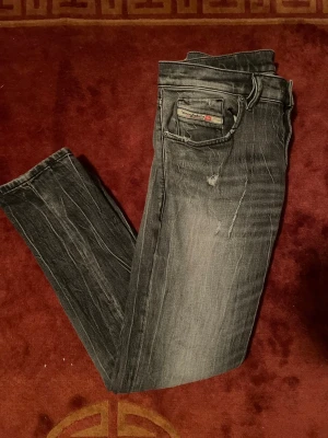 Diesel jeans - Säljer ett par svarta Diesel jeans med snygga slitningar och tvättade detaljer.  Storlek W28 Kom pv för frågor