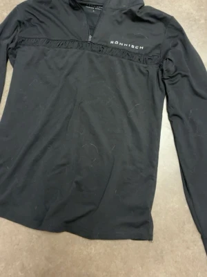 Svart  träningströja Röhnisch - Svart långärmad träningströja från Röhnisch med halv dragkedja framtill och använd ett fåtal gånger .