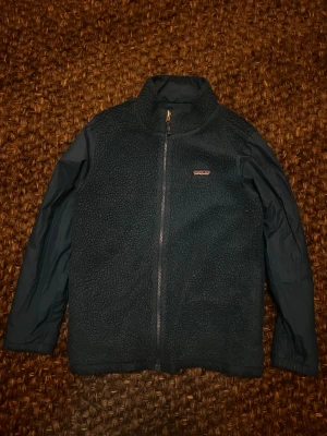 Blå fleecejacka från Patagonia - Säljer en ljusblå/turkos fleece jacka från patagonia. Jackan är reversibel så en sida är slät och vindtät och andra är fleece. Den är som en cardigan. 