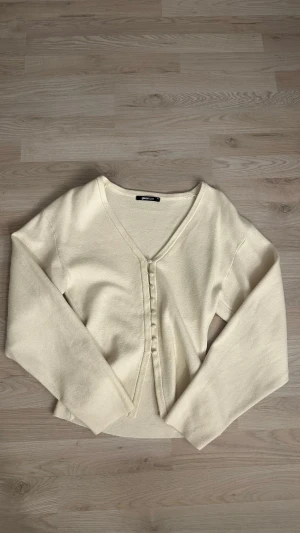 Beige kofta från Gina Tricot XS - Säljer en beige kofta från Gina Tricot i storlek XS. Koftan har v-ringad hals, långa ärmar och knappar framtill i samma färg som tyget. Säljer då den inte kommer till användning. Den är i bra skick. 