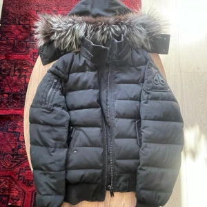 Moose Knuckles Jacka - Moose Knuckles Jacka med avtagbar luva. Gammal men funkar fortfarande bra, storlek S passar som XS. Pris kan diskuteras.