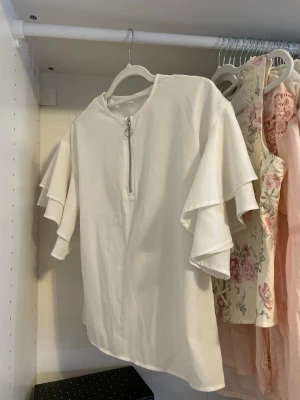 Vit blus - Vit blus med volangärmar. Passar storlek XS/S.