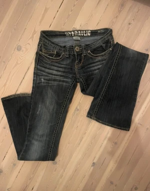 Lågmidjade bootcutjeans - Mörka bootcutjeans med väldigt låg midja och många snygga detaljer. Bra längd för mig som är 171 cm. Knappt använda!