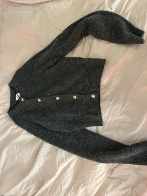 Grå stickad kofta med guld knappar  - Grå stickad kofta med guld knappar storlek S. perfekt på jul 