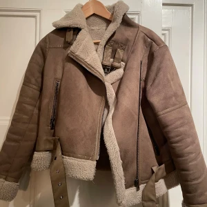 Beige teddyjacka med bälte och dragkedja - Säljer min jacka då den inte kommer till användning 💕 använts ett fåtal gånger