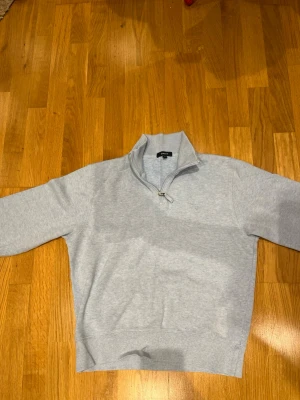 Ljusblå half zip tröja från GANT - Snygg ljusblå tröja från GANT i storlek M med half zip och ståkrage. Tröjan har långärmade ärmar och är tillverkad i mjuk bomull. Perfekt för chill dagar och enkel att matcha med jeans eller chinos.