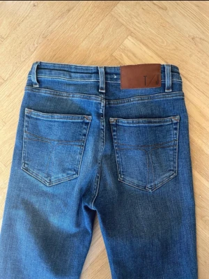 Tiger of Sweden skinny jeans blå - Snygga blå jeans från Tiger of Sweden med skinny passform och hög midja. Klassisk femficksdesign, slitna detaljer vid benslut och tydliga sömmar. Jeansen är gjorda i mjukt bomullsmaterial med lite stretch för extra komfort.