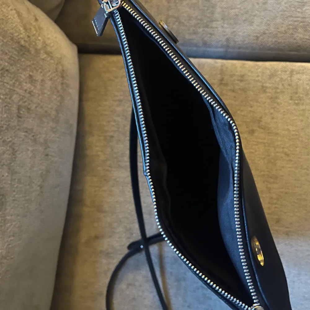 En svart väska i toppen skick som jag har för mig kommer från parfois. Den har både ett längre band och en kortare kedja så den fungerar som axelväska men även crossbody väska! Den har dessutom förvaring även i ”överdraget”. 28x20 cm🙌💕. Väskor.
