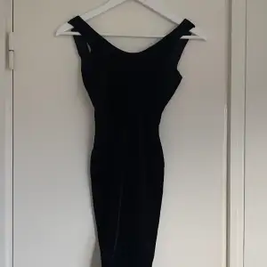 En svart klänning med djup rygg. Klänningen har stretchigt material och är kort. 