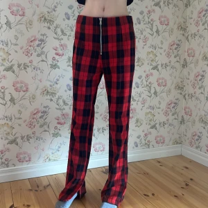Rutiga rödsvarta byxor - Rutig, rödsvart, byxor, dragkedja, inga fickor och inte trasiga. Aldrig använt