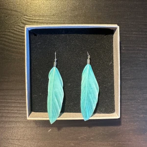Örhängen fjädrar  - Örhängen med blåa fjädrar.  Säljer flera örhängen så kolla gärna in fler i min profil. Vid köp av flera kan man få rabatt. Skriv till mig privat isåfall💗