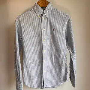 Blårandig custom fit Ralph Lauren skjorta i storlek XS. Skjortan är i fint skick utan några skavanker. Orginalpris ca 1500 kr och nu endast 499. 