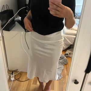 Kjol - Fin kjol i ett sorts silkes material. Går lite längre än till knäna. Dragkedja bak. 