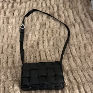 Svart flätad väska - Tänkte ta och sälja denna väska då den aldrig har kommit till användning. Lägg gärna ett eget rimligt bud.