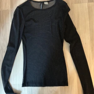Glitter tröja - Säljer denna svarta genomskinliga glittriga tröjan som bara har kommit till användning en gång.