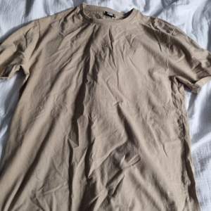 Beige basic t-shirt. Vikta ärmar som är sydda så de åker inte ner. 