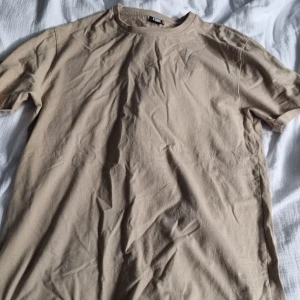Basic t-shirt - Beige basic t-shirt. Vikta ärmar som är sydda så de åker inte ner. 