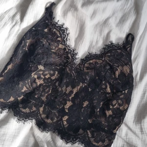 Spets linne - Svart och beige spets linne. Dragkedja på backsida och justerbara band. Aldrig använd 