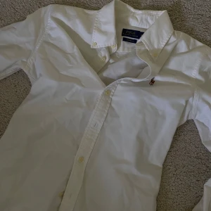 Vit polo skjorta  - I storlek 34/36. Sitter tajtare vid midjan. 