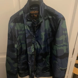 Woolrich windbreaker - Tja! Säljer denna helt nya camo windbreakern från Woolrich. Riktigt fet och passar perfekt till hösten. Köpt i Italien, tags är med. Pris kan diskuteras vid snabb affär och byten tas emot!