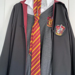 Officiell gryffindor uniform Hogwarts Harry Potter  - Harry Potter Hogwarts uniform gryffindor!! Super super fin i fantastisk kvalitet men har aldrig aldrig använts på 5 år. Har endast hängt i min garderob. Köp hela uniformen inkluderar skjortan för 2000, men 1500 för allt utan skjortan. Storlek M! 🙏🏻❤️