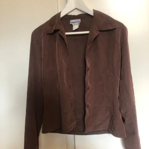 Brun skjorta - Fint skick, broderade detaljer på kragen. Mer oversized än figurnära. Svalt material 