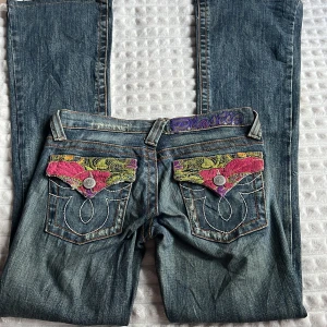 Lågmidjade jeans - Vintage ”Plastic by Gly” jeans! Är i bra skick, supersnygga bakfickor. Midjan är 36cm rakt över och innerbenslängden är 79cm.