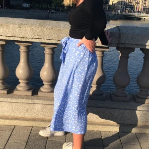 Jättesöt blå kjol - Jättefin blå kjol med rosettknyte fram, från Monki. Sparsamt använd💗 