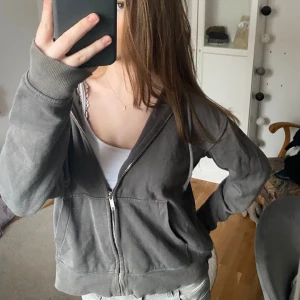 Mörkgrå zip-up - Välanvänd men i bra skick Har lite slitningar längst ner på ena ärmen 