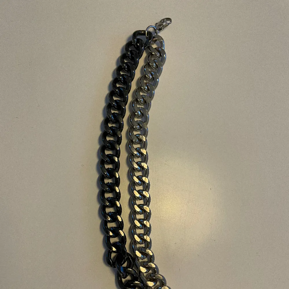 Ett armband med 2 kedjor som sitter ihop, en i svart och en i silver. Den är rätt lång så passar nog inte om du har liten handled :). Accessoarer.
