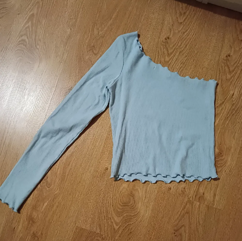 Ljusblå ribbad tröja med en ärm(vänster), använd ett fåtal gånger, mycket fint skick. Tröjor & Koftor.