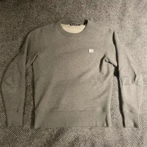 Grå face crewneck/tröja från Acne Studios. Säljs eftersom den är för liten för mig. Väldigt bra skick och använd fåtal gånger.