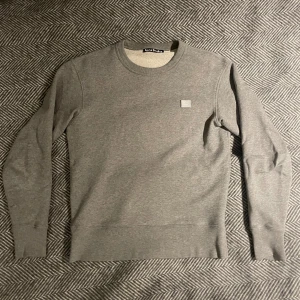 Acne studios crewneck - Grå face crewneck/tröja från Acne Studios. Säljs eftersom den är för liten för mig. Väldigt bra skick och använd fåtal gånger.