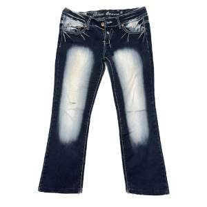 Bootcut lowrise blue queen jeans! Midjan 39 cm och innerbensmått 72 cm, passar någon som är ca 160 lång! Nästan alla rhinestones har ramlat där bak och byxorna har två slitningar vid knäna men det tillför designen och inget farligt alls 💕 