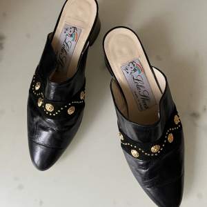 Authentic leather mules from Lola Shoes. Gorgeous lion details in gold. As seen on photos; barely used. Made in Spain.