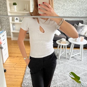 Vit topp - T-shirt med ”cut outs” framtill perfekt till sommaren. Köpt på Bik Bok, finns ej längre. Bra skick och sann i storlek. Kan vara lite genomskinlig men om man har vit eller beige bh syns det inte!