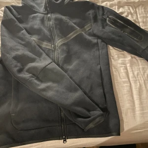 Svart Nike tech - Vill sälja min Nike tech då den bara hänger i min garderob och jag inte använder den längre priset kan diskuteras och den är äkta