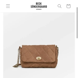 Beck Söndergaard väska - Suede Pollis bag i en jättefin brun färg med guldkedja😍 helt ny för råkade få två i present, orginalpriset är 1500 och den finns inte kvar på hemsidan, kontakta för frågor eller fler bilder!