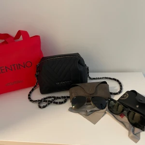 Väska och solglasögon  - Väskan: Valentino väska i väldigt fint skick. Använd Max 2 gånger. 699kr.  Solglasögon: Båda är RayBan. De svarta kostar 1200kr och de bruna 700kr.  Pris kan diskuteras vid snabb affär. 