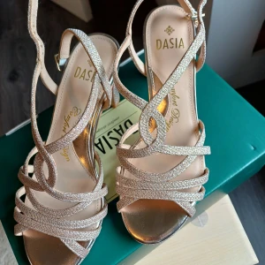 Glittriga klackar stl 38 - Superfina klackar från Dasia, stl 38. Använda under en vigsel och fotografering, så väldigt gott skick. Nypris 999:- kvitto finns samt orginalförpackning 