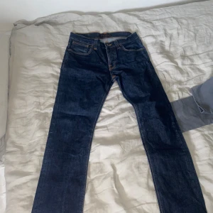 Nudie jeans grim trim  - Snygga mörkblåa nudie jeans i väldigt bra skick, inga defekter förekommer. Säljs eftersom jag bytt stil. Sitter straight/slim