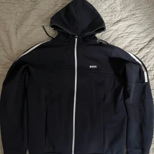 Hugo Boss Saggy 1 Hoodie - Boss hoodie från deras ”Boss Green avdelning”  Endast använd hemma har aldrig vart utanför ytterdörren. Sitter ganska stort typ som M och är lite bredare än en vanlig hoodie.   Skriv gärna om ni har fler frågor/funderingar
