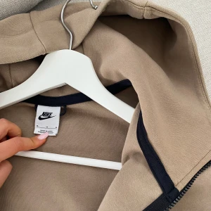 Nike Tech brun - vit - Nike Tech brun - vit Mycket bra skick, använt den kanske en gång  Tidigare köpt från JD Sports Storlek: M Pris kan diskuteras, skriv om ni är intresserade 
